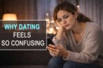 A woman sitting alone and looking at her phone, reflecting emotional confusion and exhaustion in modern dating.